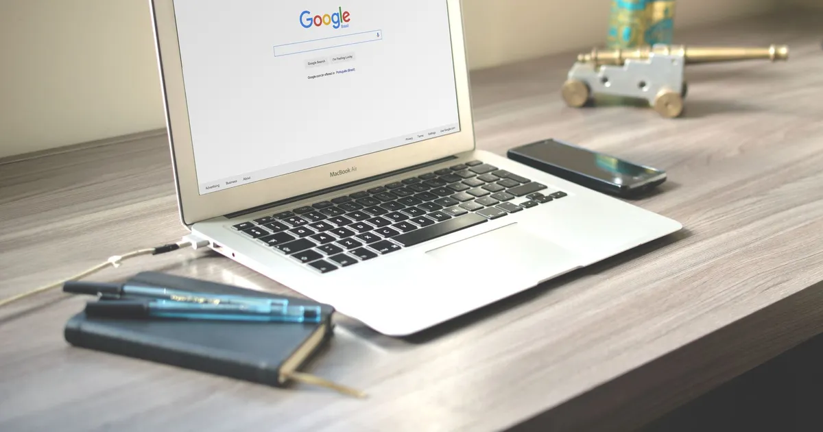 Laptop med en öppen Google-sökruta och ett anteckningsblock på skrivbordet, startpunkten för en sökordsanalys