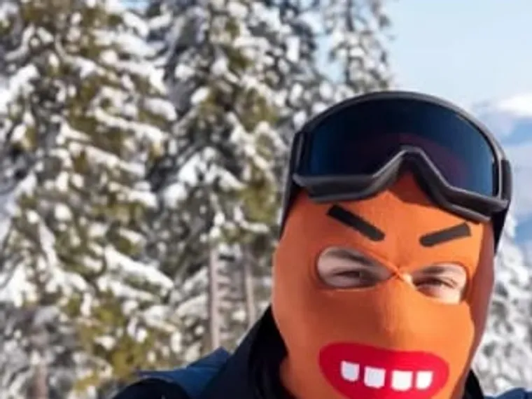 Chomp — noggos orange stickade skidmask med tänder, i skidbacken.